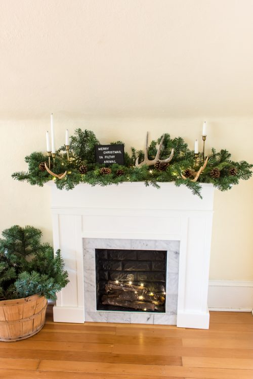 Never decorated a mantel for Christmas before? Neither had I, but it's easy! Keep your Christmas mantel simple with greenery, lights, and a few accessories. #Christmas #decor #mantel